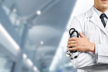 Male doctor with stethoscope on blurred hospital background