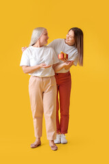 Young woman greeting her mom against color background