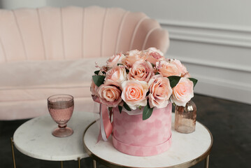 Pink bouquet in a velvet pink box on a coffee table