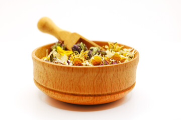Dried herbs for brewing a healthy drink. Leaves and flowers are poured into a round container. Selective focus.