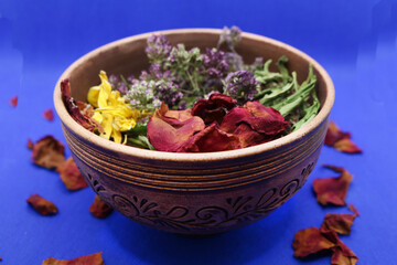 Dried herbs for brewing a healthy drink. Leaves and flowers are poured into a round container. Selective focus.