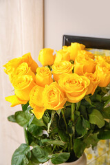Beautiful yellow roses in interior of room, closeup