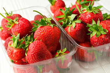 Close-up shot of freshly picked strawberries in plastic boxes
