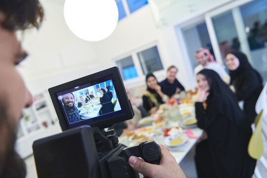 Professional videograph recording video while Muslim family having iftar together during Ramadan