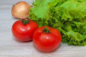 Red tomatoes and lettuce on the table. Vegetarian healthy food