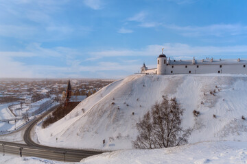 Obraz premium View of Tobolsk (Russia) - an ancient city lying under the mountain and on the mountain in a frosty winter evening. A haze spreads over the city. The houses of the townspeople, churches are visible