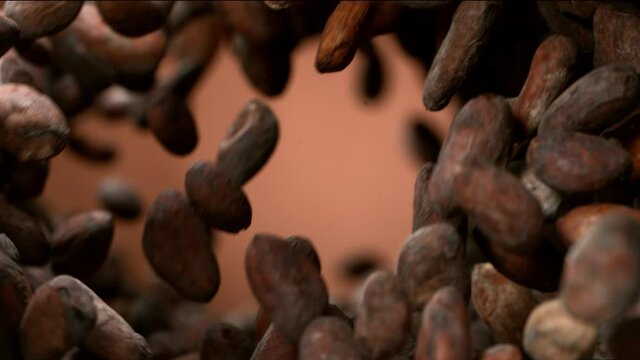 Super slow motion of flying roasted cocoa beans in rotation movement. Filmed on high speed cinema camera, 1000fps.