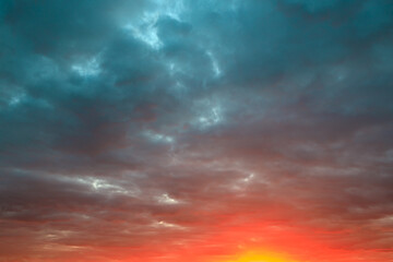 bright cloudy sky during sunset and sun at the bottom of the frame