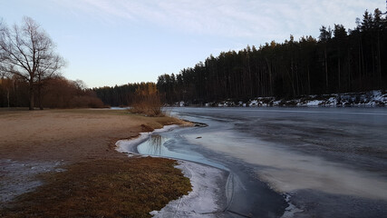 Winter landscape. Frozen river in winter on the beach.