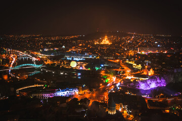 Fototapeta na wymiar Tbilisi night city panorama with passing cars sightseeing attractions. Travel Georgia blank space background