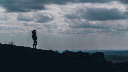 mujer sobre roca gigante mirando al horizonte