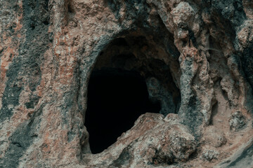 Entrada de una cueva oscura en la montaña.