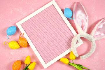 Easter product mockup with bunny ears and easter eggs on pink background flatlay. Pink felt board letterboard mock up with negative copy space for your text or design here.