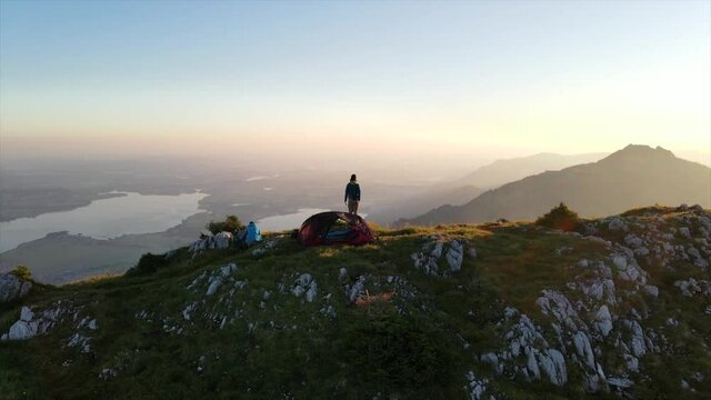 Aerial view of campers on mountain peak during sunrise, Allgäu, Germany 3