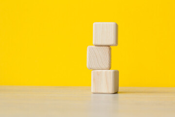 Stack wooden blocks on a yellow background