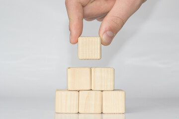 wooden blocks arranged in pyramid on Light background