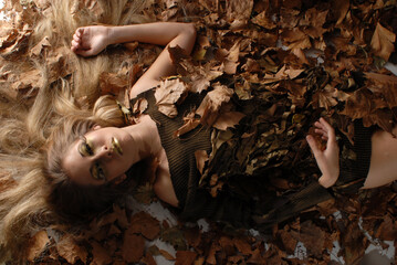 young woman made up of autumn with dry leaves of a tree representing the season of the year with...