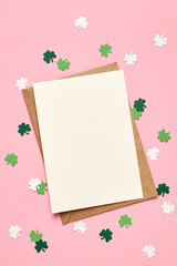 Saint Patricks day invitation card mockup with envelope, green paper shamrock on pink background