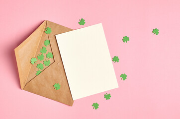 Saint Patricks day invitation card mockup with paper clover leaves on pink background