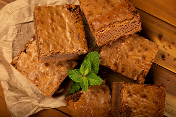 Chocolate brownies stacked with mint leaves.
