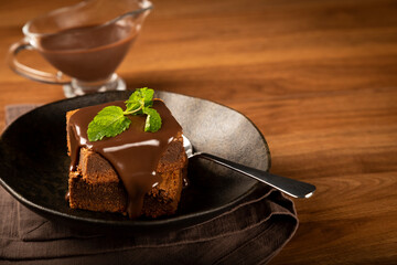 Chocolate brownies with chocolate sauce and mint leaves