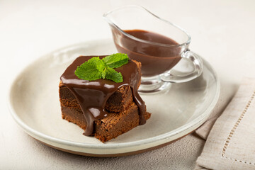 Chocolate brownies with chocolate sauce and mint leaves