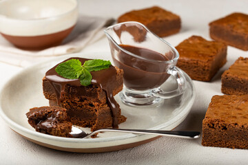 Chocolate brownies with chocolate sauce and mint leaves