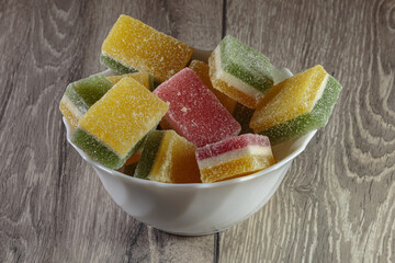 Multi colored layered marmalade in a dish. Closeup of wonderful dessert.