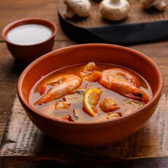 Tom yam soup with shrimps and coconut milk in a plate.