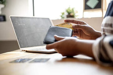 Women are taking their credit cards out of their wallets to pay for the goods they ordered through the website. Credit cards can pay for products online. Online shopping ideas.