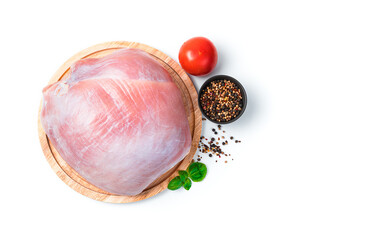 Obraz premium Raw turkey meat on a board, tomato, basil and pepper on a white background.