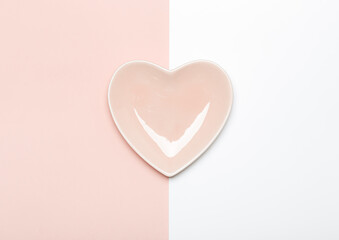 Empty pink heart shaped plate on pink and white background