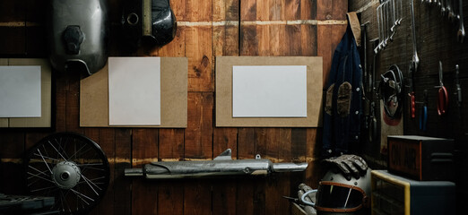Workshop scene. Old tools hanging on wall in workshop, Tool shelf against a table and wall, vintage garage style, with blank paper