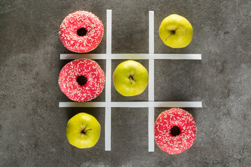 Healthy vs unhealthy food, green apples vs donuts in tic tac toe game