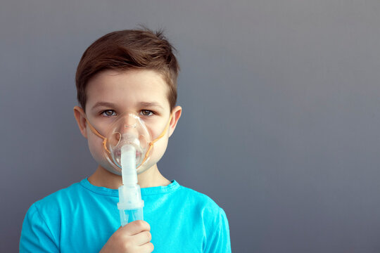 A boy receives respiratory tract treatment through a nebulizer during illness. Inhalation procedures. Healthcare and medicine concept.