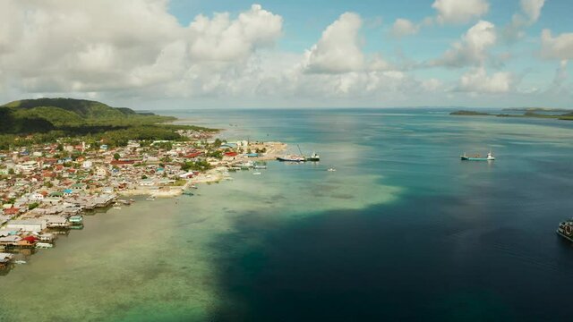 Ferry terminal with ferry and ships in the town of Dapa, Siargao island, from above. Summer and travel vacation concept