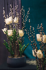 Flower arrangement, made of tulips and catkin on a decorated table