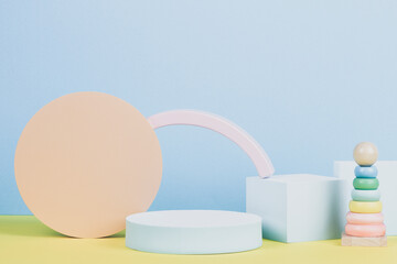 Baby kid toy background. Composition of colorful educational toys and geometric shapes podium, platform on blue and yellow background