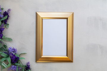 Gold frame mockup and lilac on gray wash background flat lay copy space