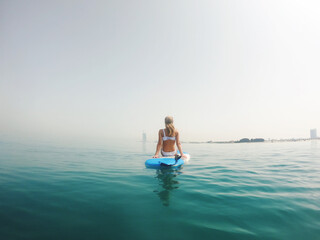 Woman sitting on the paddle board with a view on Burj Al Arab