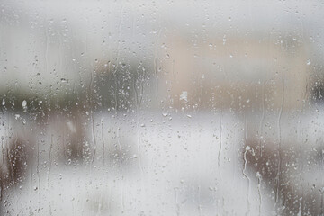 Close up macro view of raindrops with snow on a window pane. Beautiful spring backgrounds of nature. Sweden.