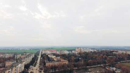 Obraz premium Aerial view of a small town, green fields, park, highways against the sky. Ukraine