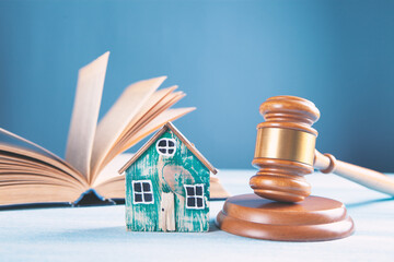 Judge gavel and houses on a wooden background. The concept of a real estate auction or division of a house in case of divorce.