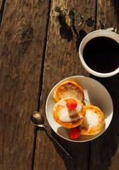cheese pancakes and coffee on a wooden background