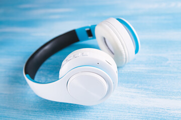 Top view of white headphones on blue background with copy space.