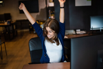 Joyful woman at her desk in the office