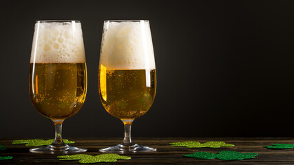 Two Glass of Beer or Ale on wooden table and clover leaves on black background. St. Patrick's Day. Feast of Saint Patrick celebration held on 17 March. Macro photography. Close-up with copy space