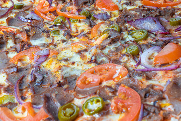 Kebab pizza with tomatoes and onions, close-up.