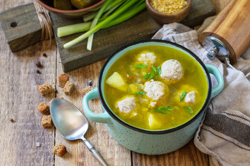 Healthy and diet food. Soup with meatballs and bulgur on a wooden table.