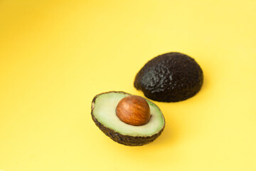 avocado  cut in half isolated on pastel yellow background